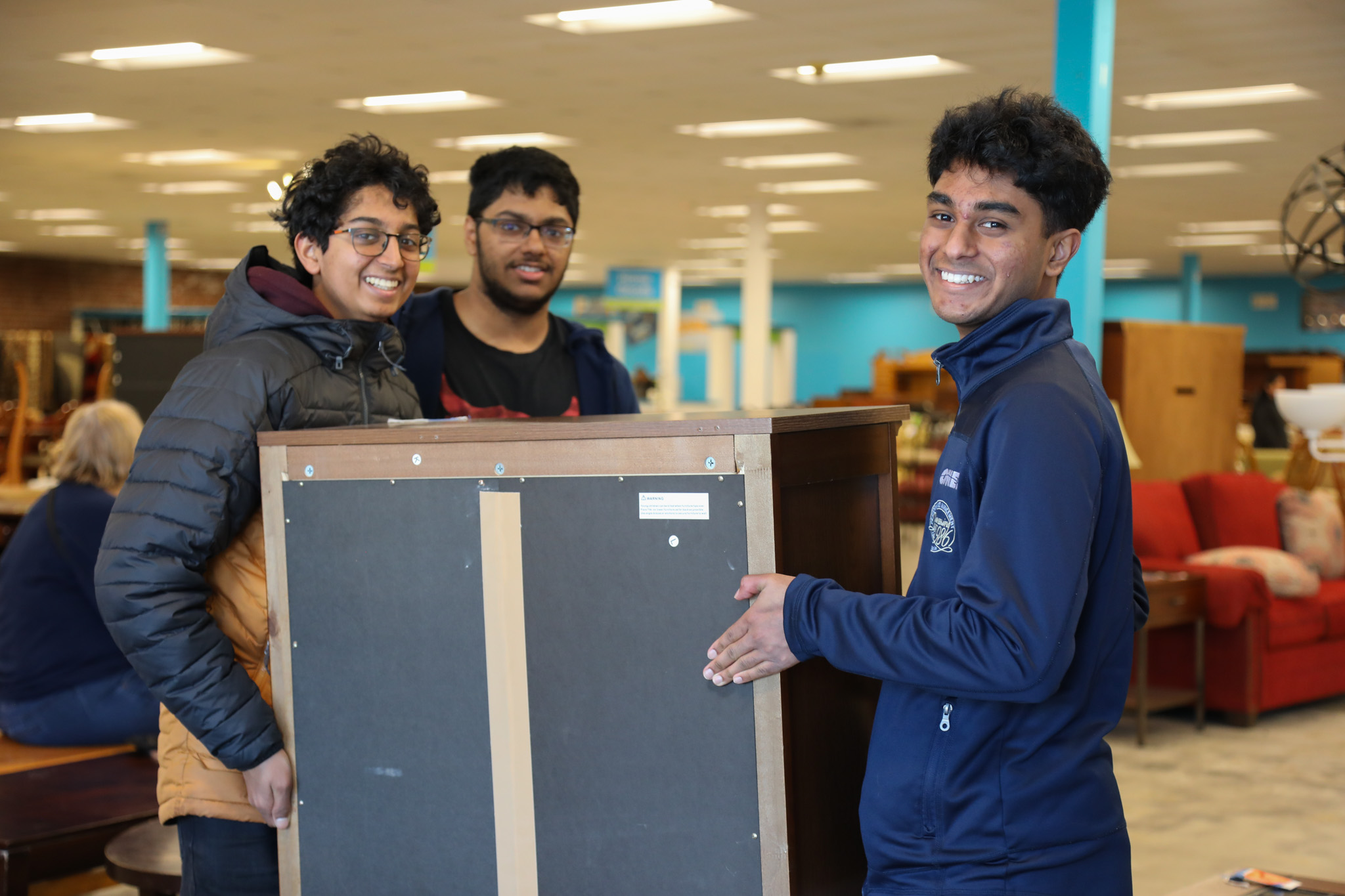 student volunteers moving furniture at the ReStore