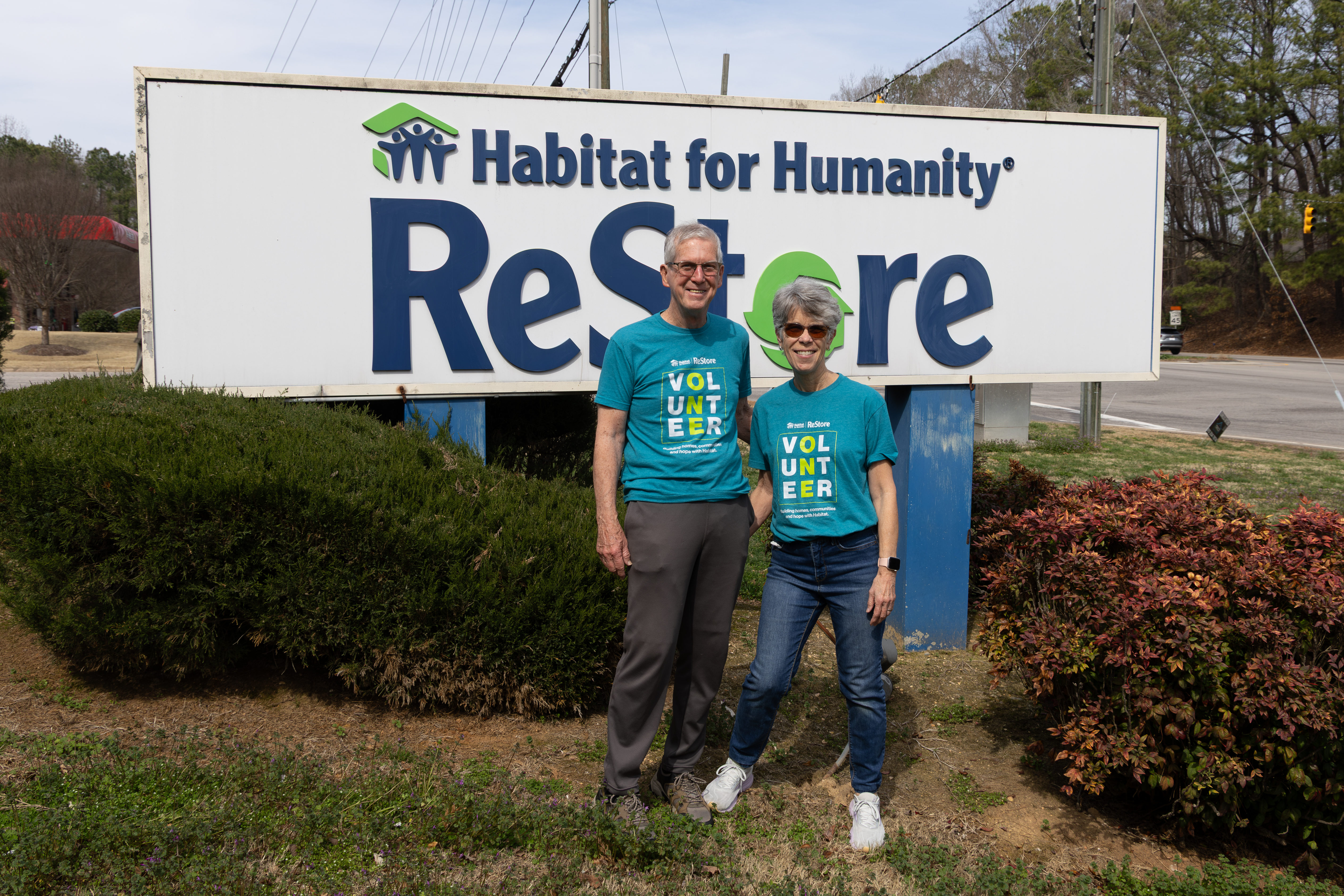 Core Volunteers Joe and Lillis standing outside Glenwood Habitat ReStore