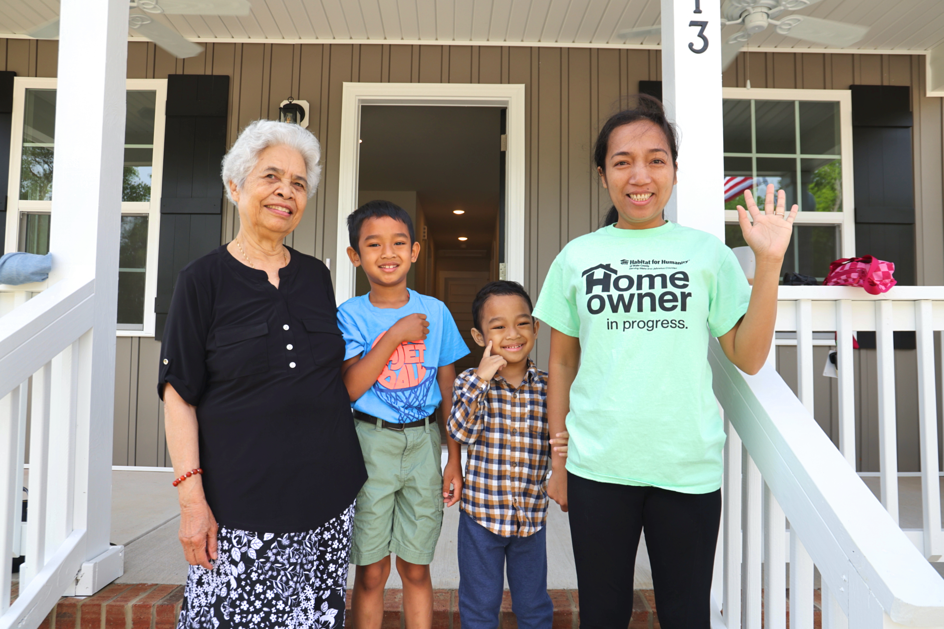 Habitat homeowner family standing outside completed Habitat home