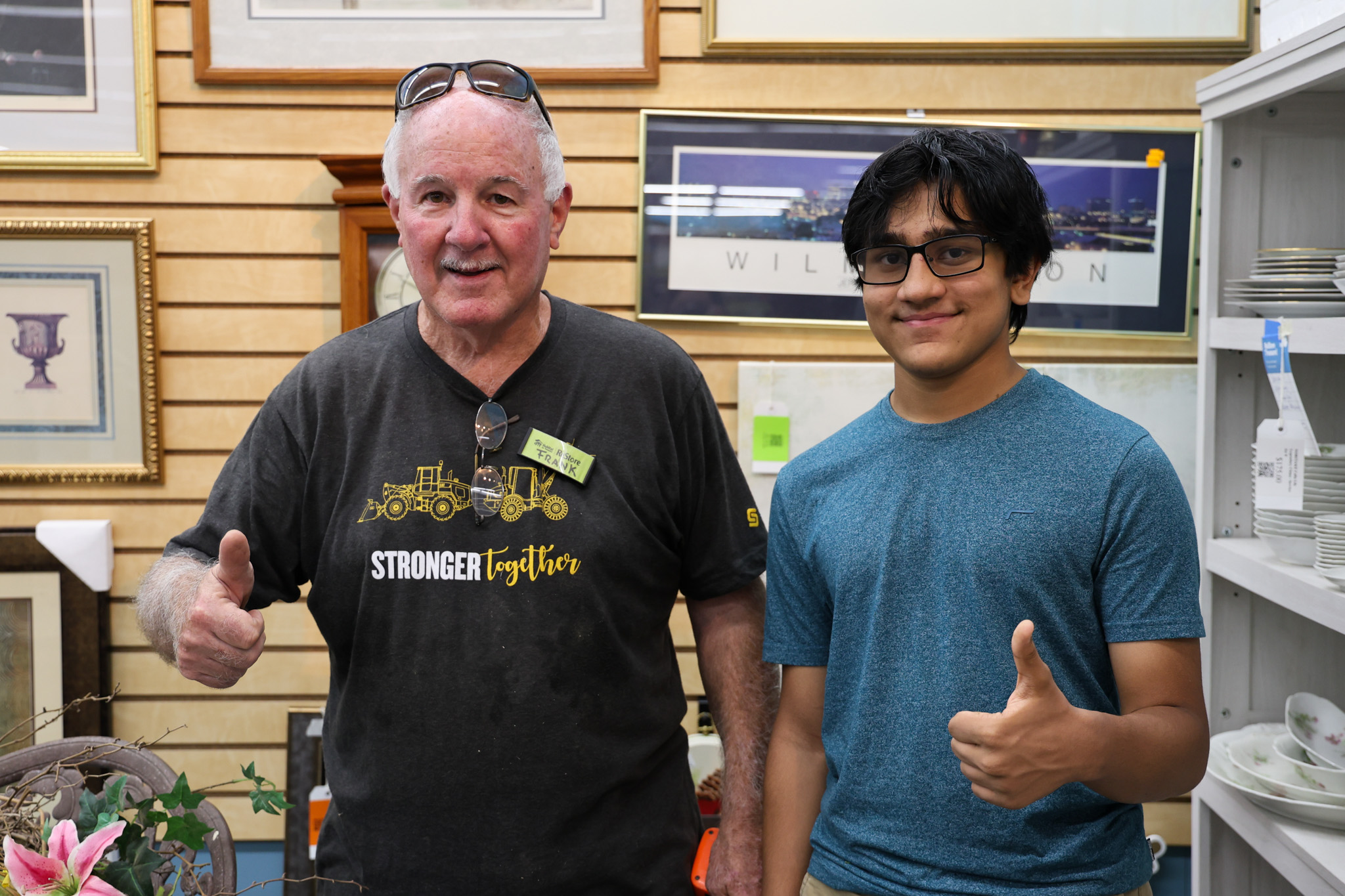 High school student volunteer Naveen stands with core volunteer Frank at the Cary ReStore