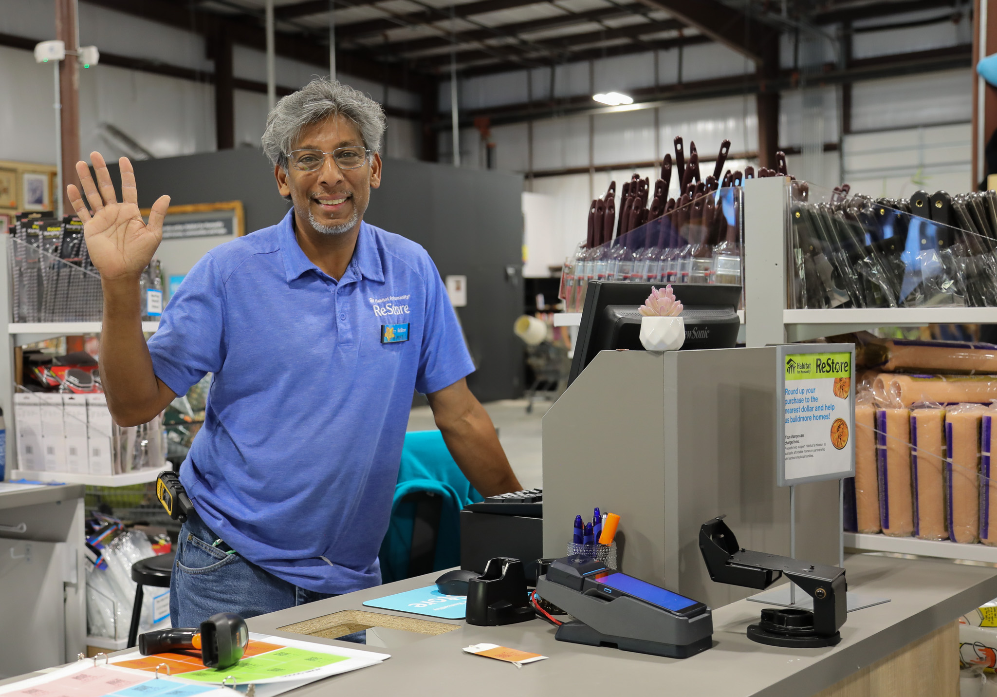 ReStore staff smiling and waving from behind the register