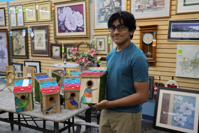 high school student holds up birdhouse at the Cary ReStore