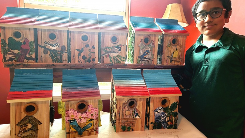 Naveen with the 10 birdhouses he created